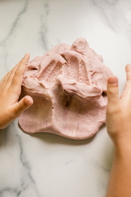 Child's hands making a handprint in aromatherapy playdough