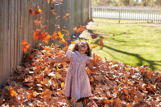 Little girl playing in leaves