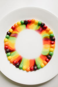 Skittles on a white plate making a rainbow