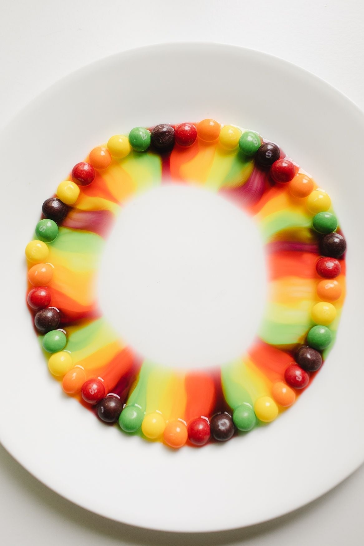 Skittles on a white plate making a rainbow