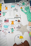 Load image into Gallery viewer, Educational materials on a table including a Constitution crossword, label match, and cut-out figures of the Statue of Liberty and bald eagle.
