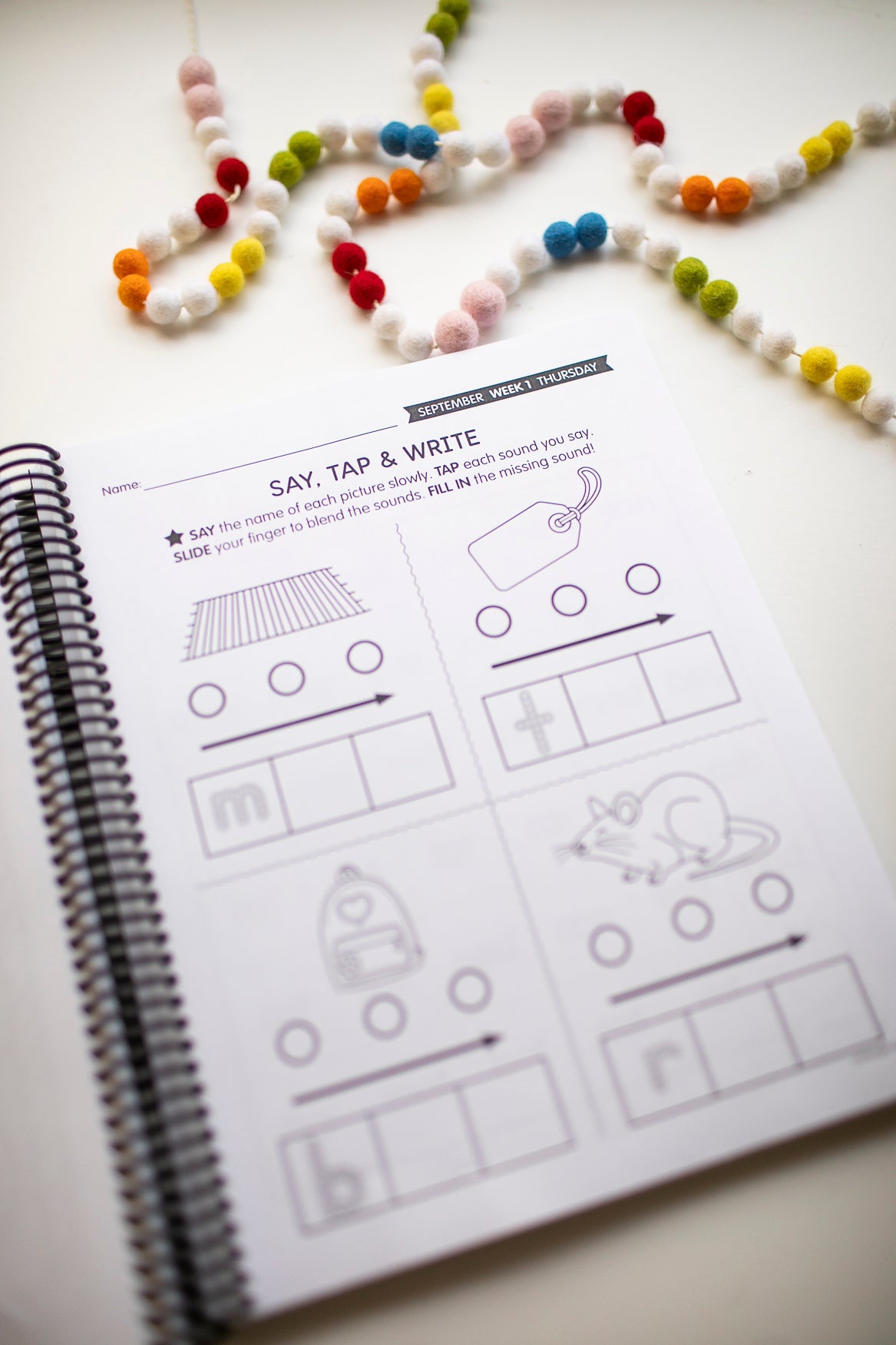 Children's educational worksheet about the science of reading with coloring and tracing activities on a white surface with colorful beads.