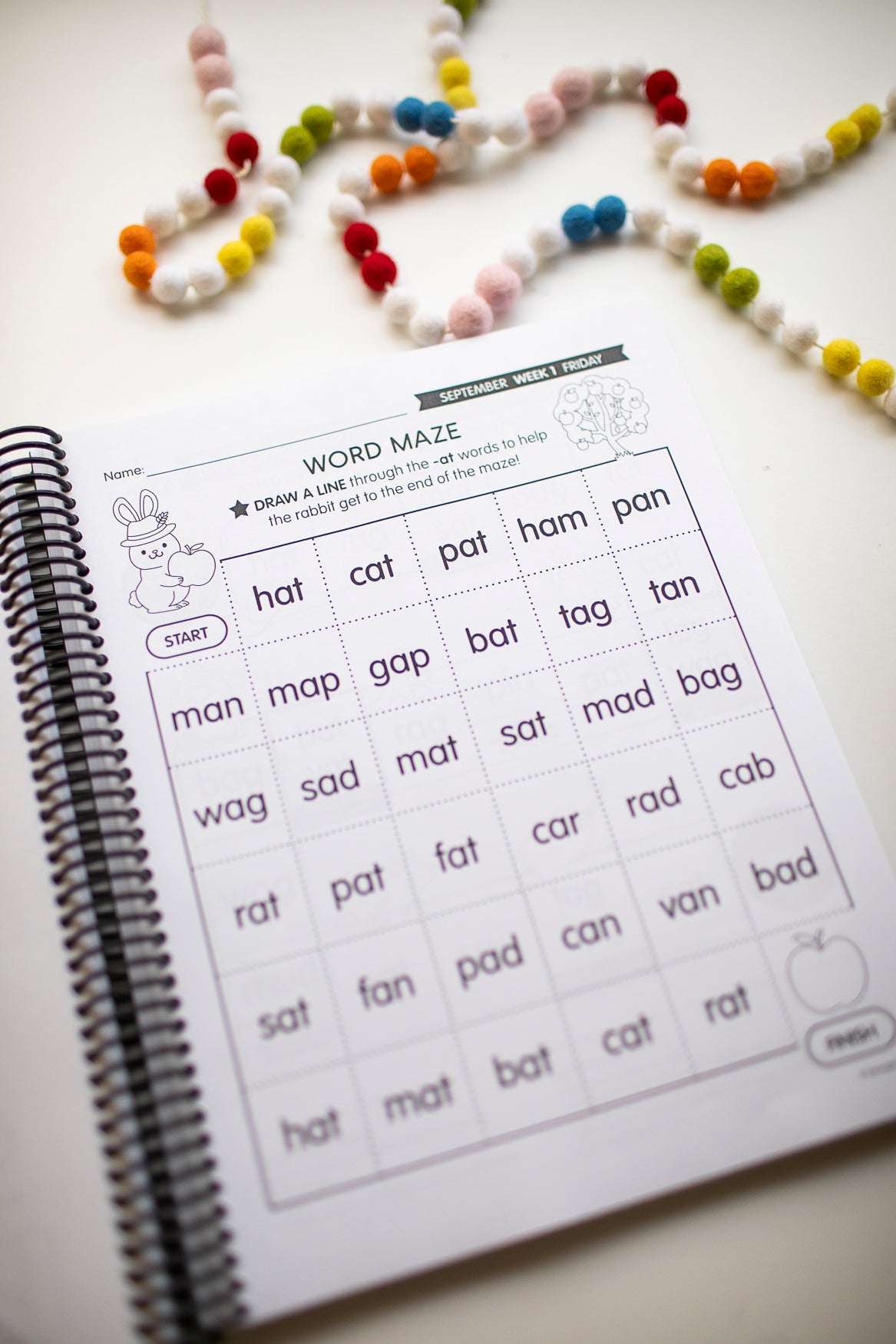 Word maze activity sheet with colorful beads on a white surface